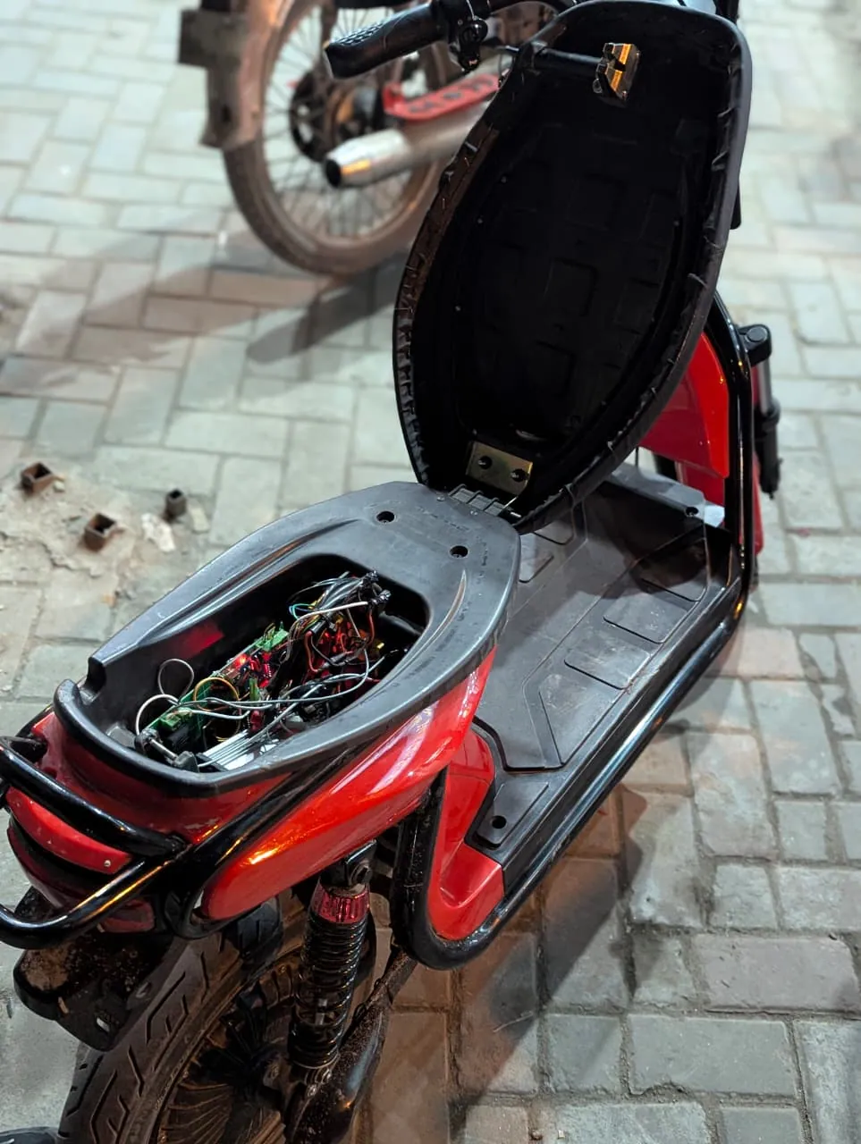 The electric bike with its seat open and the telemetry hardware installed underneath