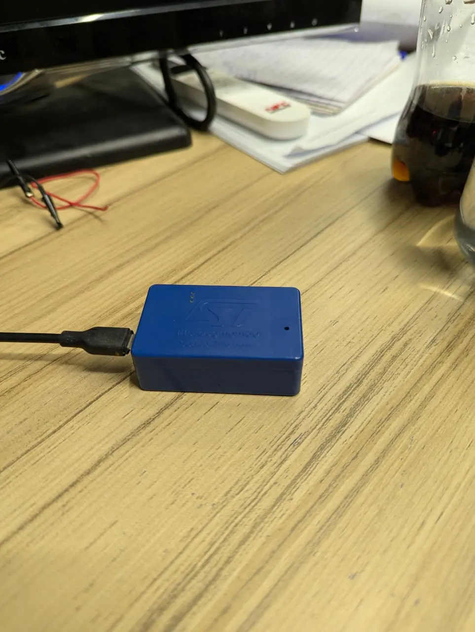 Wrist-worn IMU prototype in a blue enclosure on a desk
